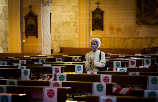 A woman prays at the San Miguel Basilica in Palma de Mallorca on May 11, 2020 as Spain moved towards easing its strict lockdown in certain regions. - One of the worst-hit countries, Spain plans a phased transition through to end-June, with around half of the 47 million population being allowed out to socialise to a limited degree from Monday and restaurants offering some outdoor service. (Photo by JAIME REINA / AFP)