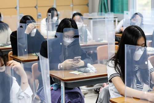 Senior students wait for class to begin with plastic boards placed on their desks at Jeonmin High School in Daejeon, South Korea, Wednesday, May 20, 2020. South Korean students began returning to schools Wednesday as their country prepares for a new normal amid the coronavirus pandemic. (Kim Jun-beom/Yonhap via AP)