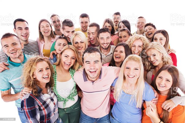 Large group of happy young people standing embraced and looking at the camera. Isolated on white.