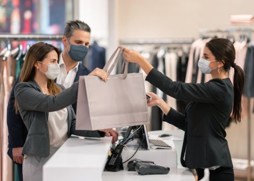 Latin American couple shopping at a clothing store and using facemasks during the pandemic while paying at the till (Latin American couple shopping at a clothing store and using facemasks during the pandemic while paying at the till , ASCII, 118 co